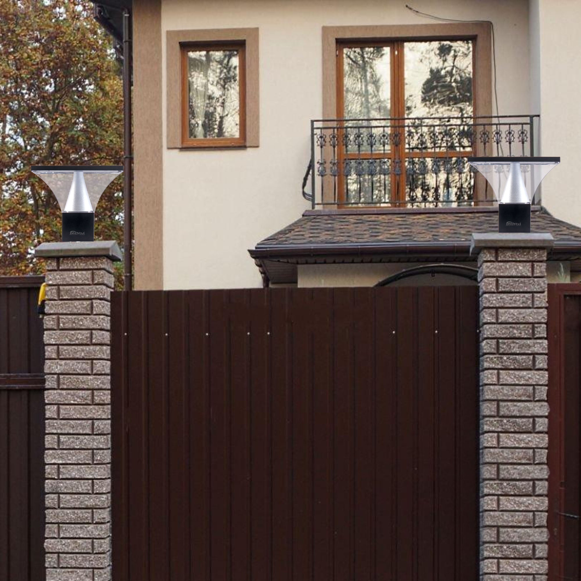 Modern gate post lanterns with flared design lighting brick pillar entry