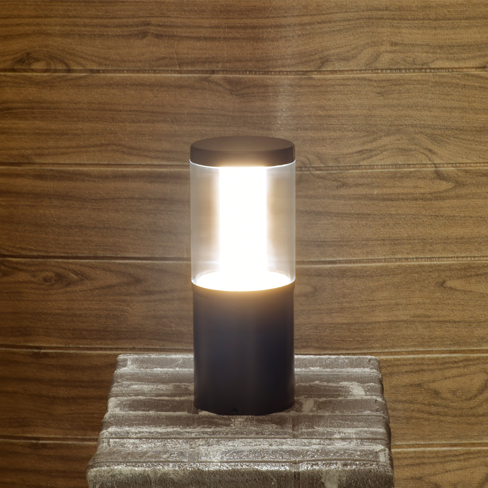 Cylindrical LED lamp on a stone base against a wooden wall